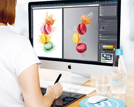 A person in front of a Mac workstation